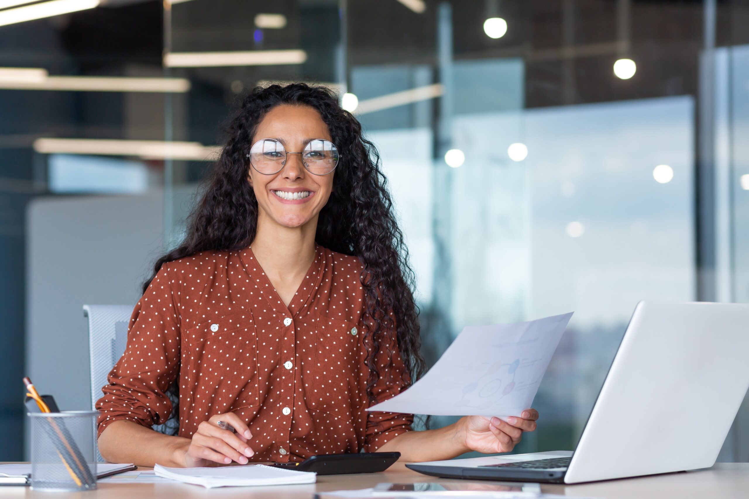 Businesswoman in a financial services firm with paper work and a laptop connected by Kinetic Business Dedicated Fiber Internet