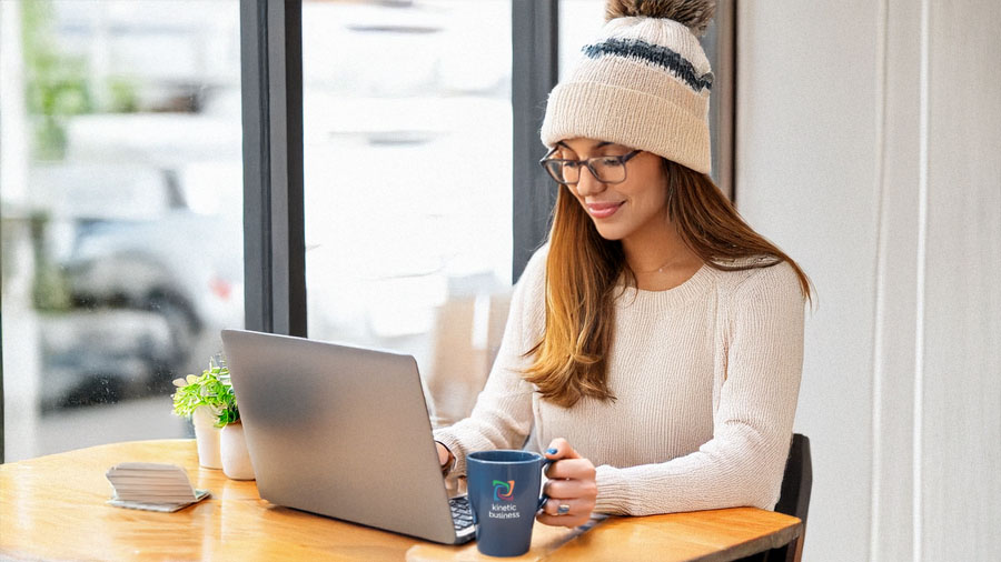 Young woman in cafe uses WiFi powered by Kinetic Business on her laptop