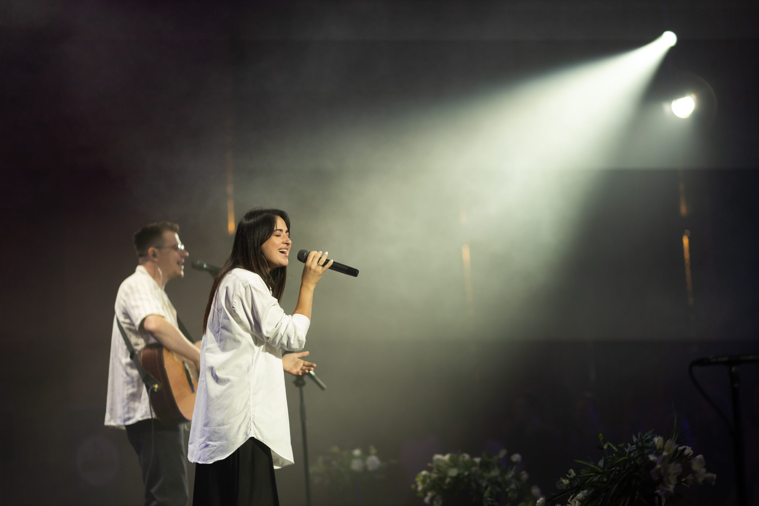 Worship band sings on stage in church under spotlight, live streamed using high speed internet provided by Kinetic Business