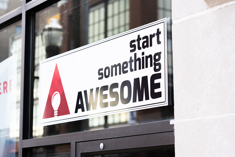 Start Something Awesome sign hands in front of the Awesome, Inc headquarters
