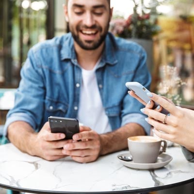 Male cafe patron using wireless device.