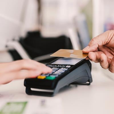 Credit card machine with two hands and a credit card.