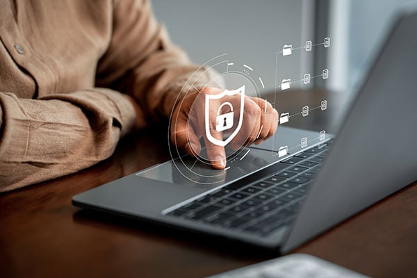 Typing on laptop with security badge superimposed